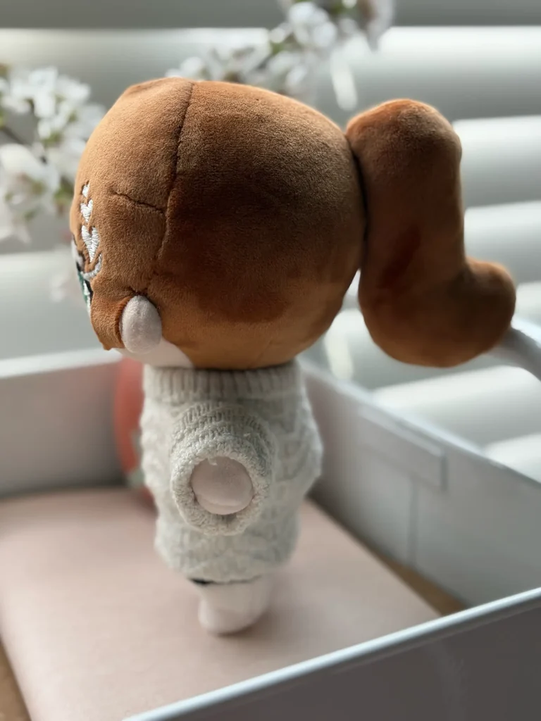 Side view of the cotton doll showcasing its curled ponytail.